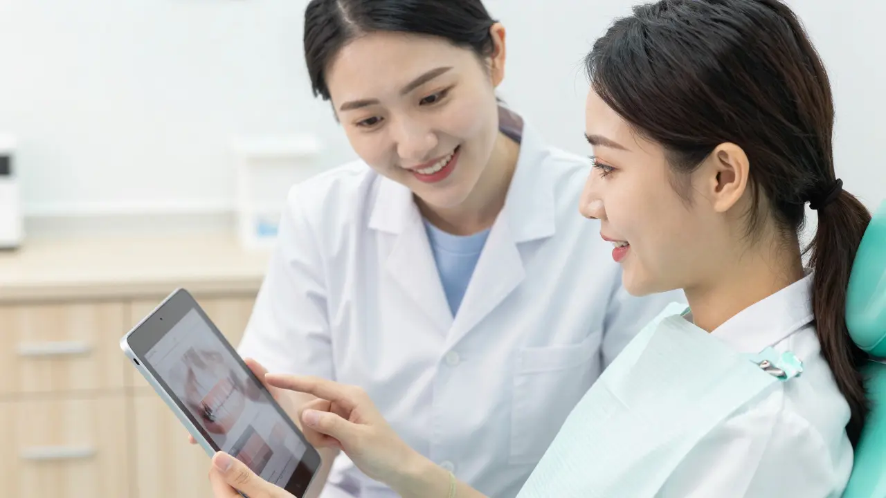 Young woman reviewing dental treatment plan with doctor